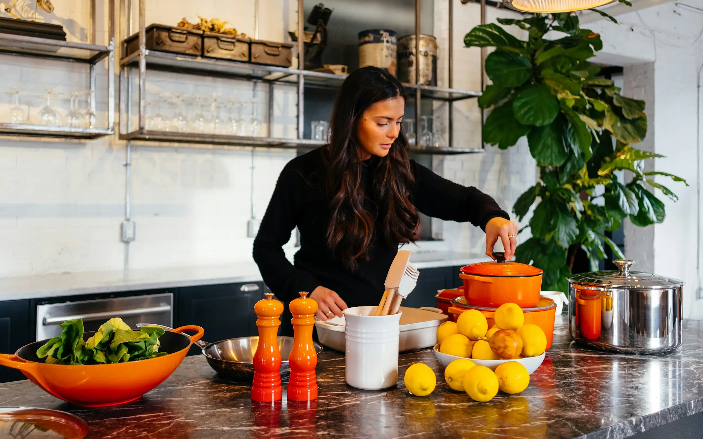 Mutfakta limon ve sebzelerle yemek hazırlayan bir kadın